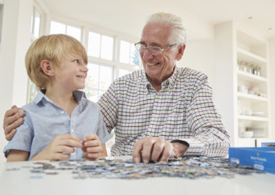 Senior man and grandson doing a jigsaw puzzle